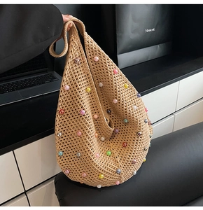 Detail of hand-woven mesh beach bag with colorful faux pearls and crochet texture