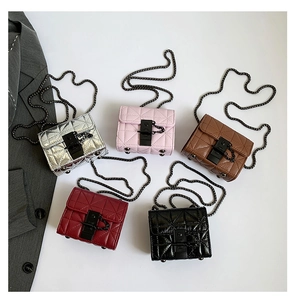 Flat lay of five mini quilted chain crossbody bags in silver, pink, brown, red, and black