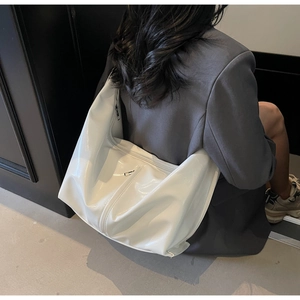 Détail du grand sac Hobo blanc brillant en cuir verni avec fermeture éclair argentée