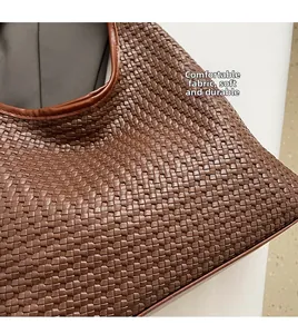 Detailed close-up of dark brown woven leather texture on a soft oversized tote bag