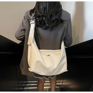 Vue arrière d'un sac demi-lune blanc avec fermeture éclair verticale et large bandoulière