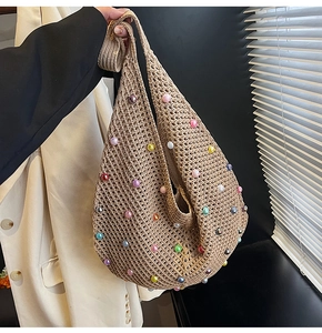 Detail of crochet knit beach bag featuring colorful pearl beads and hollow weave texture