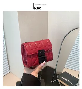 Close-up of red quilted mini bag with black metal chain strap and luxury leather texture