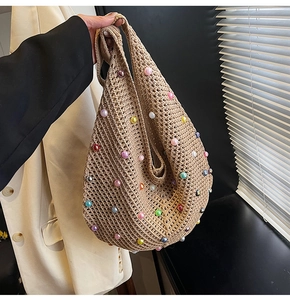 Detailed knit texture of a beige mesh shoulder bag with colorful pearls accents