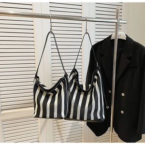 Detail of black and white striped mesh tote bag with smooth leather shoulder straps