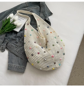 Detail of hollow knit mesh bag featuring colorful pearl beads and a beige woven texture