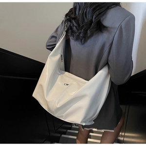 Gros plan d'un grand sac hobo blanc avec un détail métallique argenté minimaliste