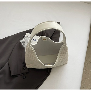 Top view of woven tote bag with smooth white leather handles and golden magnetic buckle