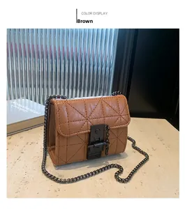 Detailed view of brown quilted crossbody bag with metal lock and chain strap