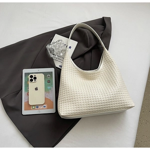Close-up of white woven hobo bag showing intricate V-shape textured patterns and minimalist design