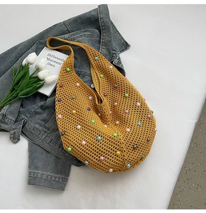 Detail of yellow hollow knit shoulder bag featuring colorful pearl bead decorations