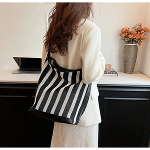 Detail view of large striped knit tote bag showing the mesh texture and leather base