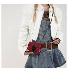 Chic red quilted chain bag styled with a white leather jacket and denim dress