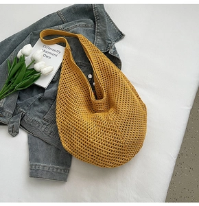 Detail of hollow knit mesh texture on mustard yellow crochet shoulder beach bag