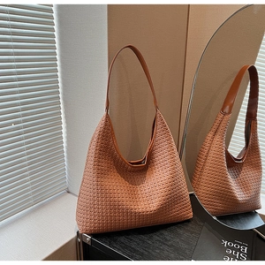 Detailed view of brown woven hobo bag showing intricate texture and premium leather straps
