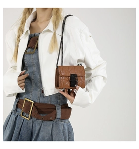 Detailed view of a brown quilted mini chain bag worn by a model in a studio setting