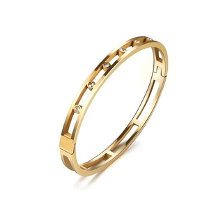 Close-up of golden hollow double-rail bangle with five sparkling inlaid cubic zirconia