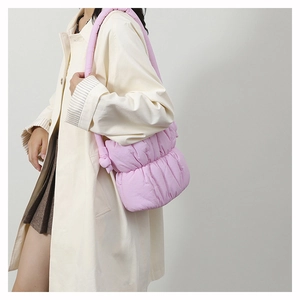 Detailed view of pink quilted cloud bag with padded shoulder strap on a model