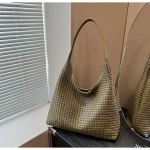 Close-up of olive green woven tote bag with intricate faux leather texture and minimalist handle
