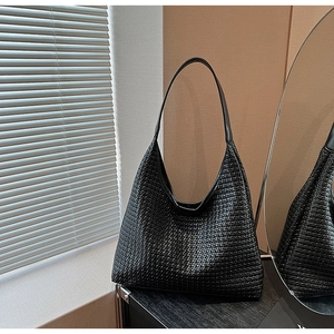 Close-up of woven texture on a large black tote bag featuring premium craft details