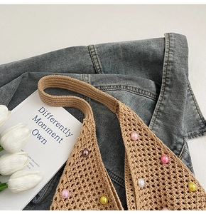 Detail of crochet knit beach bag with colorful pearl beads and floral arrangement