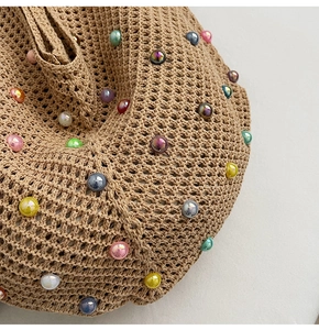 Detail of crochet beach bag featuring colorful pearl beads and intricate knit mesh texture