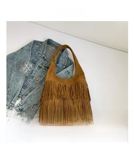 Detailed view of the layered brown fringe tassels on a vintage matte suede tote bag