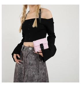 Detail of pink quilted leather mini square bag with black chain strap held by a model