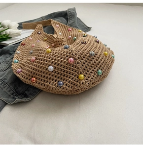 Detail of hand-woven beige knit bag featuring colorful pearl beads and texture