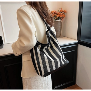 Detail of black and white striped knit hobo bag with high-quality leather shoulder strap