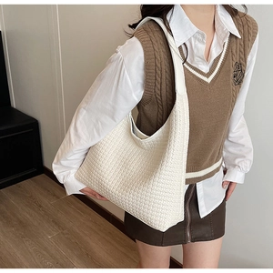 Detail shot of white woven hobo bag showing large capacity and soft faux leather texture
