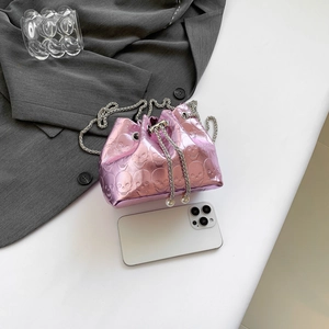 Metallic pink drawstring bucket bag with skull embossing and silver chain strap