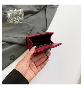 Detail view of the red quilted mini bag interior with chain strap and shiny leather finish
