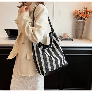 Close-up of black and white striped hobo bag featuring mesh texture and leather trim