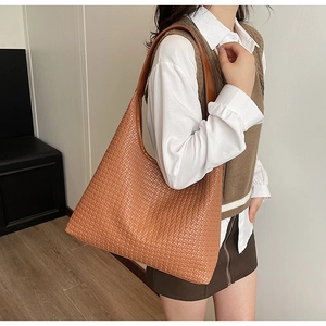 Detail of caramel brown woven tote bag showing the large capacity and PU leather texture