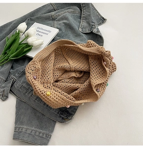 Detailed knit texture of brown hollow-out mesh bag with colorful pearl embellishments