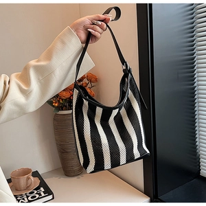 Detail of black and white striped mesh hobo bag with adjustable leather strap