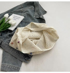 Detail of off-white crochet mesh tote bag featuring colorful pearl bead accents