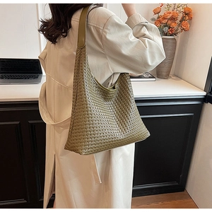 Detail of dark olive green woven leather texture on a large capacity hobo shoulder bag