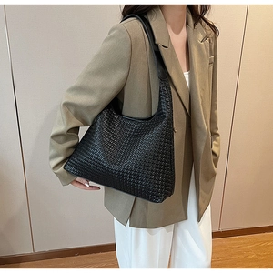 Close-up of black woven hobo bag showing the intricate premium leather texture on shoulder