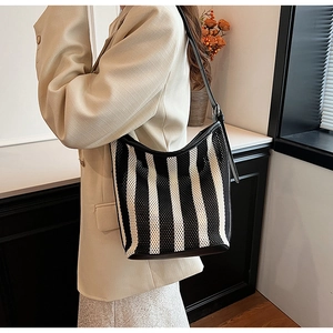 Detail of hobo shoulder bag with black and white vertical stripes and mesh texture