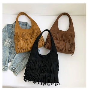 Detailed flat lay of three suede fringe handbags in yellow, brown, and black colors