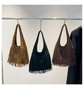Three bohemian suede shoulder bags with double-layered tassels in brown, black, and tan