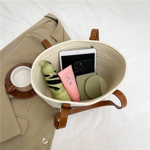Cream woven straw tote bag with brown leather handles and large capacity storage