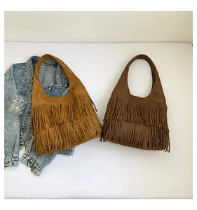 Detail of vintage suede hobo bags with long fringes in camel and dark brown tones