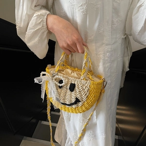 Handmade straw bucket bag featuring a woven smiley face and elegant pearl lace decorations