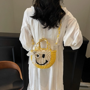 Straw beach bag with yellow smiley face design, top handles and shoulder strap for women