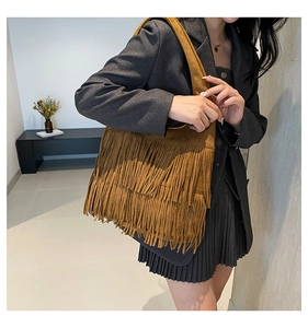 Detail of vintage brown suede shoulder bag with dense three-layer tassel decoration