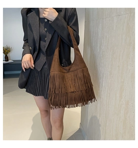Detail shot of the multi-layered fringe tassels on a vintage brown suede hobo bag