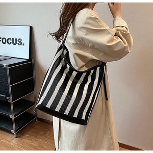 Detail of black and white striped mesh hobo bag with reinforced leather strap joints